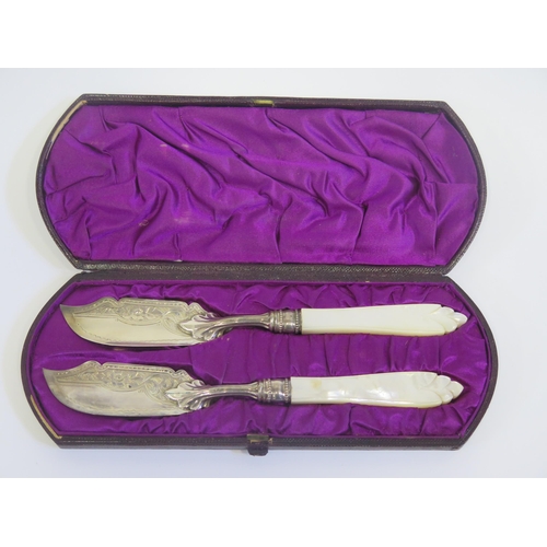 38 - A Cased Pair of Victorian Silver and Mother of Pearl Butter Knives with chased foliate decoration, B... 