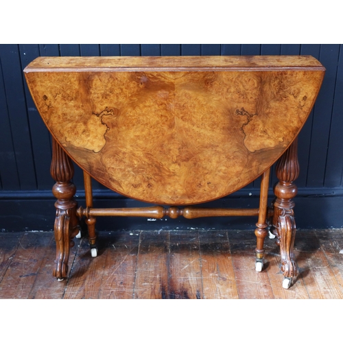 260 - A Victorian Burr Walnut Sutherland Table raised on turned and reeded columns with white porcelain ca... 