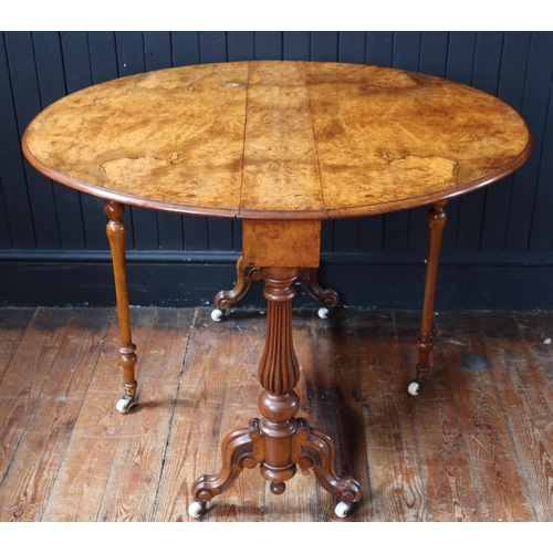 260 - A Victorian Burr Walnut Sutherland Table raised on turned and reeded columns with white porcelain ca... 