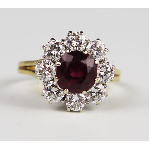 303b - An 18ct Yellow Gold, Ruby and Diamond Cluster Ring, the 6.5 mm principal stone surrounded by 8 x c. ... 