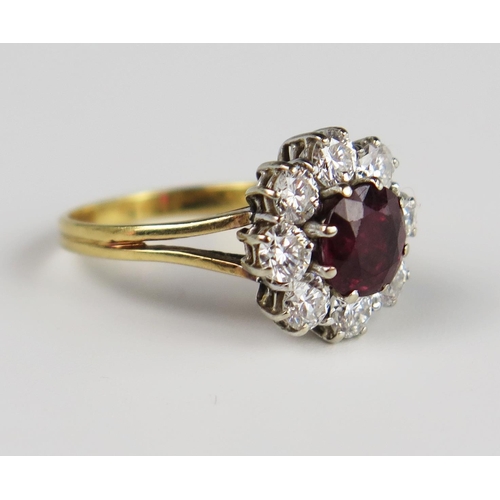 303b - An 18ct Yellow Gold, Ruby and Diamond Cluster Ring, the 6.5 mm principal stone surrounded by 8 x c. ... 