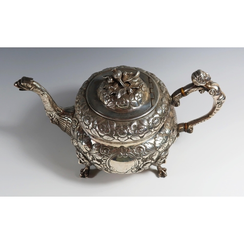 31 - A George III Irish Silver Teapot with heavily embossed decoration, mask and bird's head spout, mask ... 