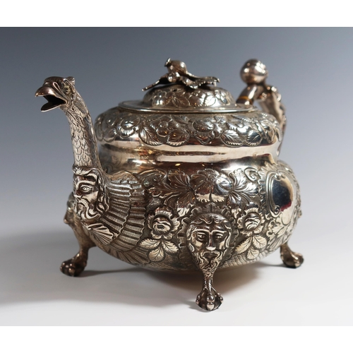 31 - A George III Irish Silver Teapot with heavily embossed decoration, mask and bird's head spout, mask ... 