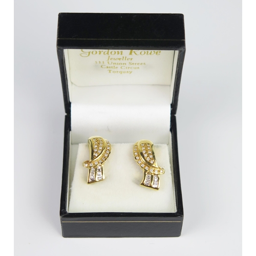 334 - A Pair of 18ct Yellow Gold and Diamond Bow Clip on Stud Earrings set with baguette and round cuts, t... 