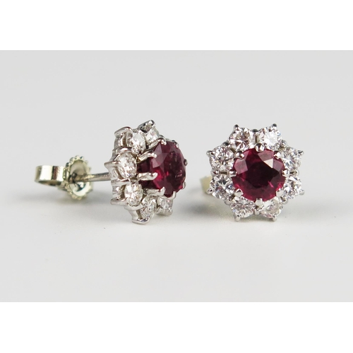 335 - A Pair of Ruby and Diamond Cluster Stud Earrings, the central c. 5.2mm stones surrounded by eight c.... 