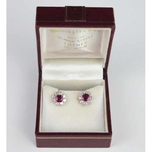 335 - A Pair of Ruby and Diamond Cluster Stud Earrings, the central c. 5.2mm stones surrounded by eight c.... 