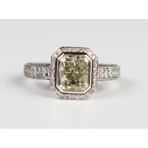 339 - A Hans D. Krieger Radiant Cut Diamond Ring in a rub over setting surrounded by brilliant cut stones ... 