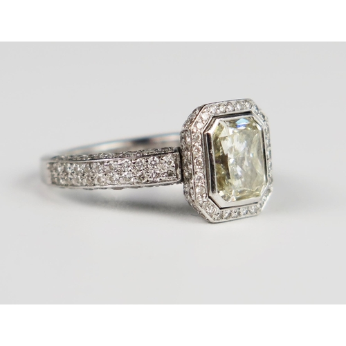 339 - A Hans D. Krieger Radiant Cut Diamond Ring in a rub over setting surrounded by brilliant cut stones ... 