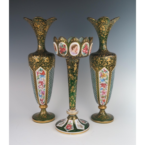 369 - A 19th Century Bohemian Glass Garniture, the green ground with white opaque overlay and polychrome f... 