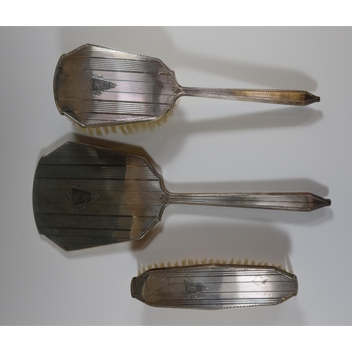57 - A George VI Silver Backed Three Part Hand Mirror and Brush Set with engine turned decoration and ini... 