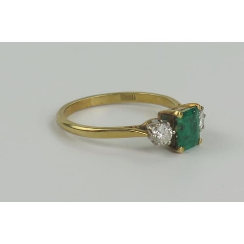 163 - 18ct Gold, Emerald and Diamond Three Stone Ring, the central 6.5x5mm stone flanked by 3.5mm diamonds... 