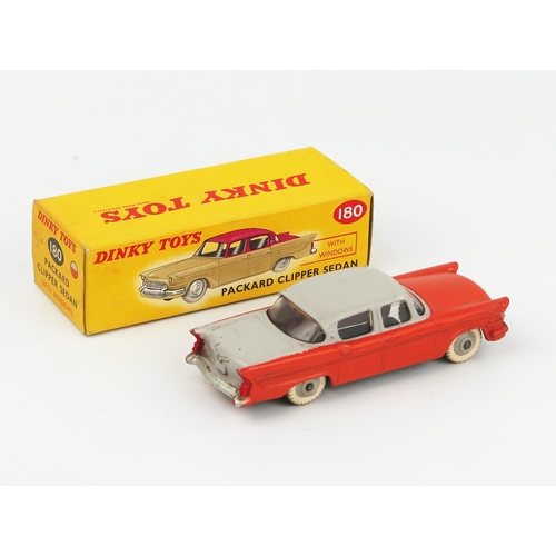 2076 - A Dinky Toys 180 Packard Clipper Sedan with grey upper body, orange lower body and grey hubs in corr... 