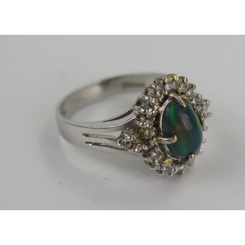 217 - A 14K White Gold, Fire Opal and Diamond Dress Ring, the 10.5x5.8mm singlet stone with a good range o... 