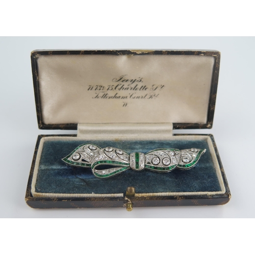 235 - A Belle Epoque Platinum, Emerald and Diamond Millegrain Set Bow Brooch, the principal 3mm diamonds w... 