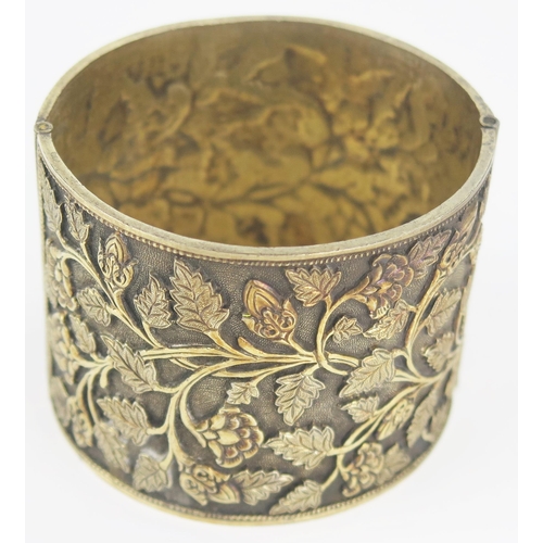 297 - Nineteenth Century Indian Silver Gilt Bangle with relief and chased foliate decoration, 49mm wide, 5... 