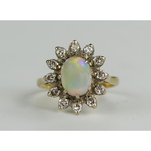 399 - 18ct Gold, Fire Opal And Diamond Cluster Ring, the central 8x7mm stone with a good range of reds, gr... 