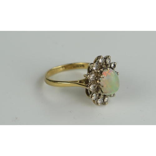 399 - 18ct Gold, Fire Opal And Diamond Cluster Ring, the central 8x7mm stone with a good range of reds, gr... 