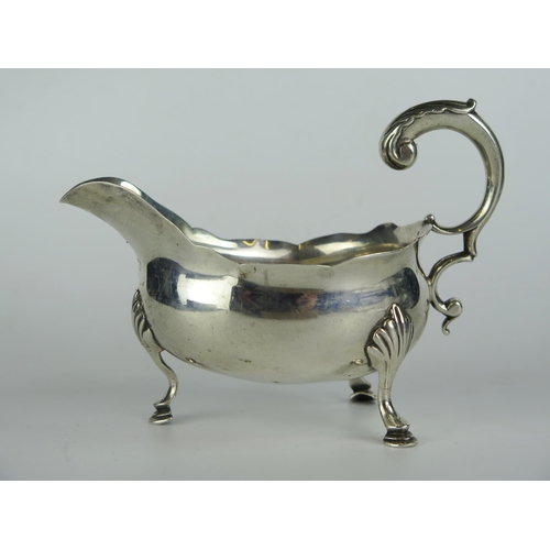 637 - George III Silver Sauce Boat with foliate scroll handle and standing on three hoof feet, 14.5cm long... 