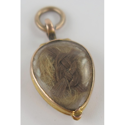 9 - Georgian Memorial Locket in an unmarked gold setting with hinged compartment containing hair, 27mm d... 