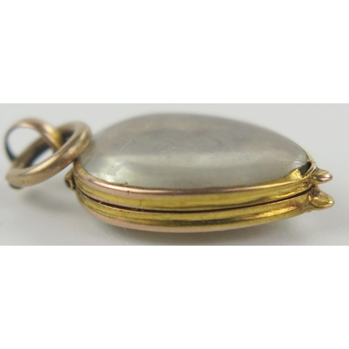 9 - Georgian Memorial Locket in an unmarked gold setting with hinged compartment containing hair, 27mm d... 