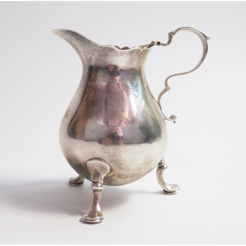 514 - A George II silver cream jug, of plain baluster form, raised in three cabriole legs, London 1742, EH... 