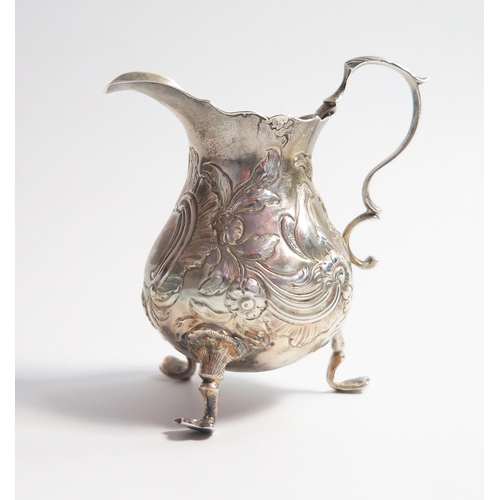 517 - A George II silver cream jug, of baluster form, high c scrolled handle, three cabriole legs, London ... 