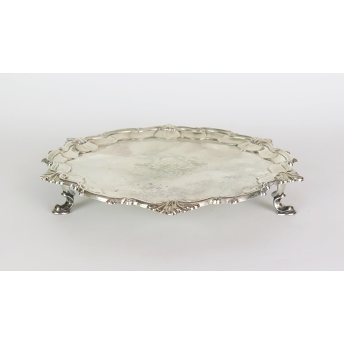 525 - A George II silver waiter, of circular form, with scroll and shell piecrust border, central engraved... 