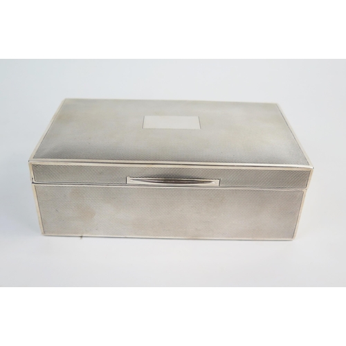 589 - An early 20th Century silver cigarette box, of rectangular form, engine turned decoration with blank... 