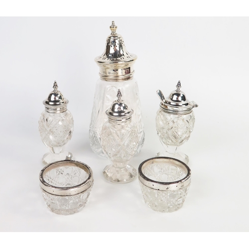 591 - A silver and glass sugar dredger, together with a pair of pepper pots, a mustard pot with a mustards... 