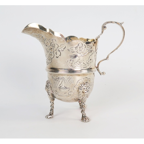 602 - An Edwardian silver helmet shape cream jug, raised on three lion mask legs with paw feet, London 190... 