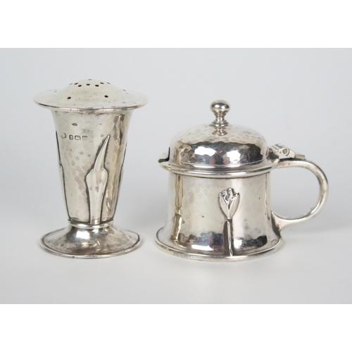 606 - An Arts and Crafts silver mustard pot and pepperette, knop finial, domed hinge lid, C handle, hammer... 