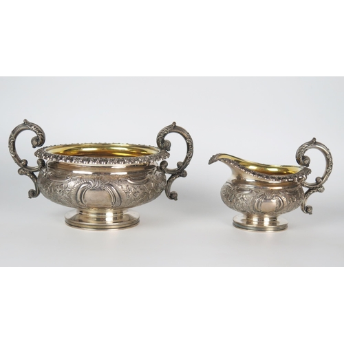 609 - A George IV silver milk and sugar basin, of compress urn form, embossed floral decoration, high C sc... 