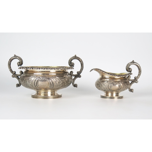 609 - A George IV silver milk and sugar basin, of compress urn form, embossed floral decoration, high C sc... 