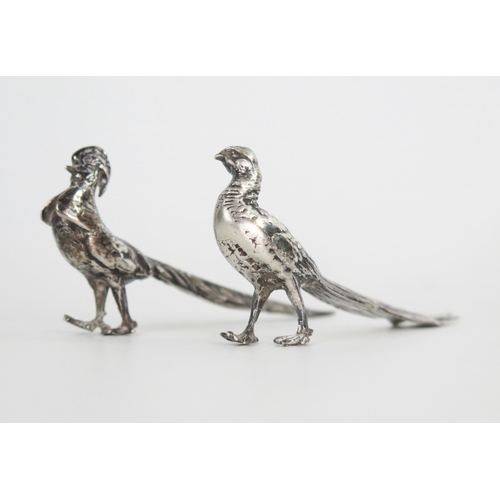 627 - A pair of cast silver miniature pheasants, cock and hen, 8cm long, 60grams.