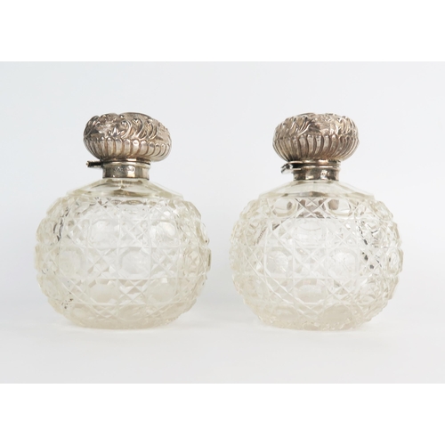 632 - A pair of silver and glass globe dressing table scent bottle, hinge silver tops with glass stoppers,... 