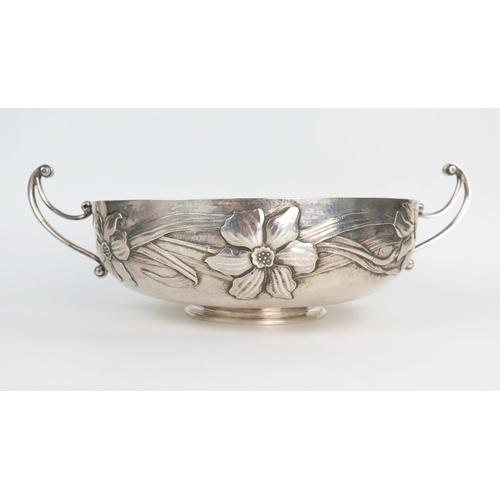 647 - An impressive Arts and Crafts two handle bowl, of compressed circular form, hammered ground with emb... 