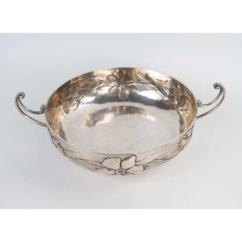 647 - An impressive Arts and Crafts two handle bowl, of compressed circular form, hammered ground with emb... 