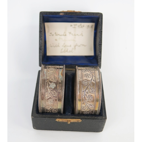 649 - A cased pair of Arts and Crafts silver napkin rings, Birmingham 1906, C&N.