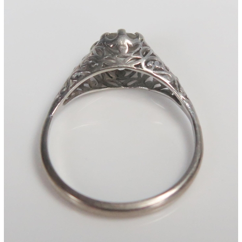 98A - 18ct White Gold and Diamond Solitaire Ring in a pierced scroll setting and with four small diamonds ... 