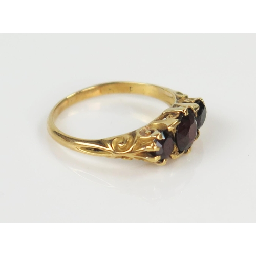 99 - 18ct Gold and Garnet Three Stone Ring, marks rubbed, size K.5, 2.9g