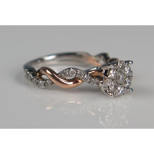 141 - 10K Rose and White Gold Multi Stone Ring, the 7mm  head set with seven round cuts and further to the... 