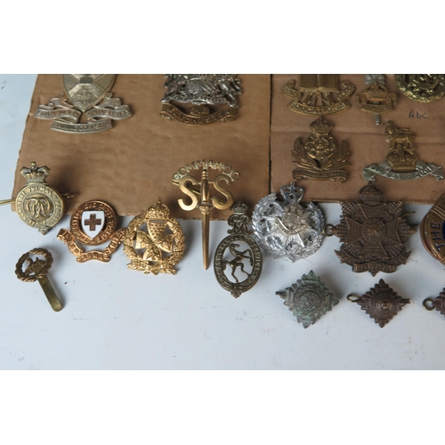 169 - Large Selection of Military Cap Badges including Monmouth Regiment of Welsh Guards, 1st Royal Devon ... 