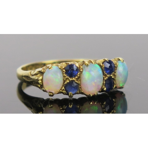 21 - White Opal and Sapphire Ring in an 18ct hallmarked gold setting, 17mm head, size K.75, Birmingham 19... 