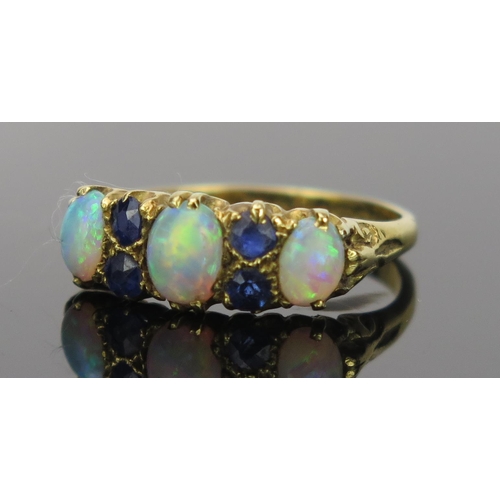 21 - White Opal and Sapphire Ring in an 18ct hallmarked gold setting, 17mm head, size K.75, Birmingham 19... 