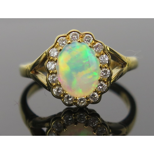 23 - White Opal and Diamond Cluster Ring in an 18ct hallmarked gold setting, 9x7mm central stone, 13x11mm... 