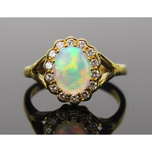 23 - White Opal and Diamond Cluster Ring in an 18ct hallmarked gold setting, 9x7mm central stone, 13x11mm... 