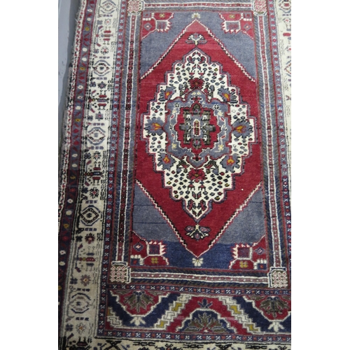 409 - A late 20th Century Persian style wool rug, red and dark blue, 188x109cm.