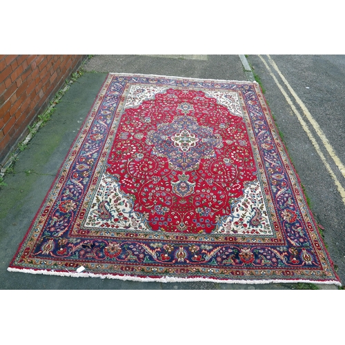 410 - A 20th Century Kashan style wool carpet, blue central medallion, red field, cream spandrels, blue bo... 