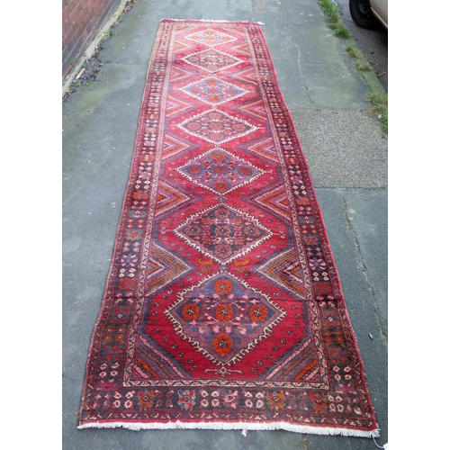 412 - A large 20th Century Turkish Runner, wool carpet, geometric diamond lozenges, red ground, pyramid gr... 