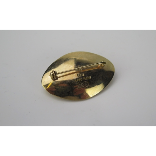 1002 - A mid 20th Century 9 carat gold and Tigers eye cabochon brooch of oval form, with pin catch, stamped... 